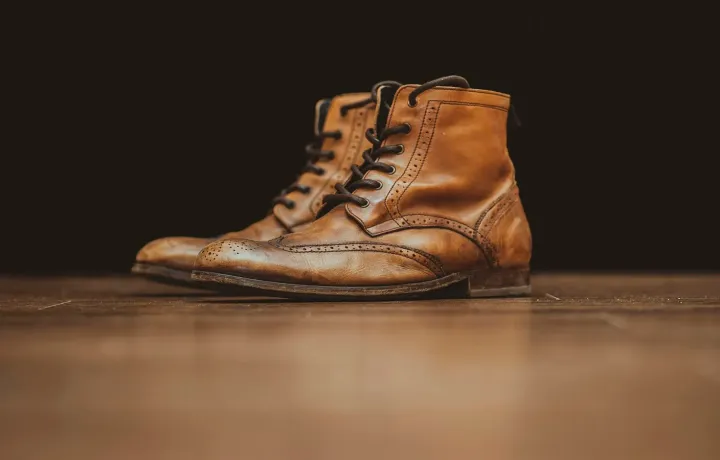 Par de botas de couro marrom sobre bancada escura