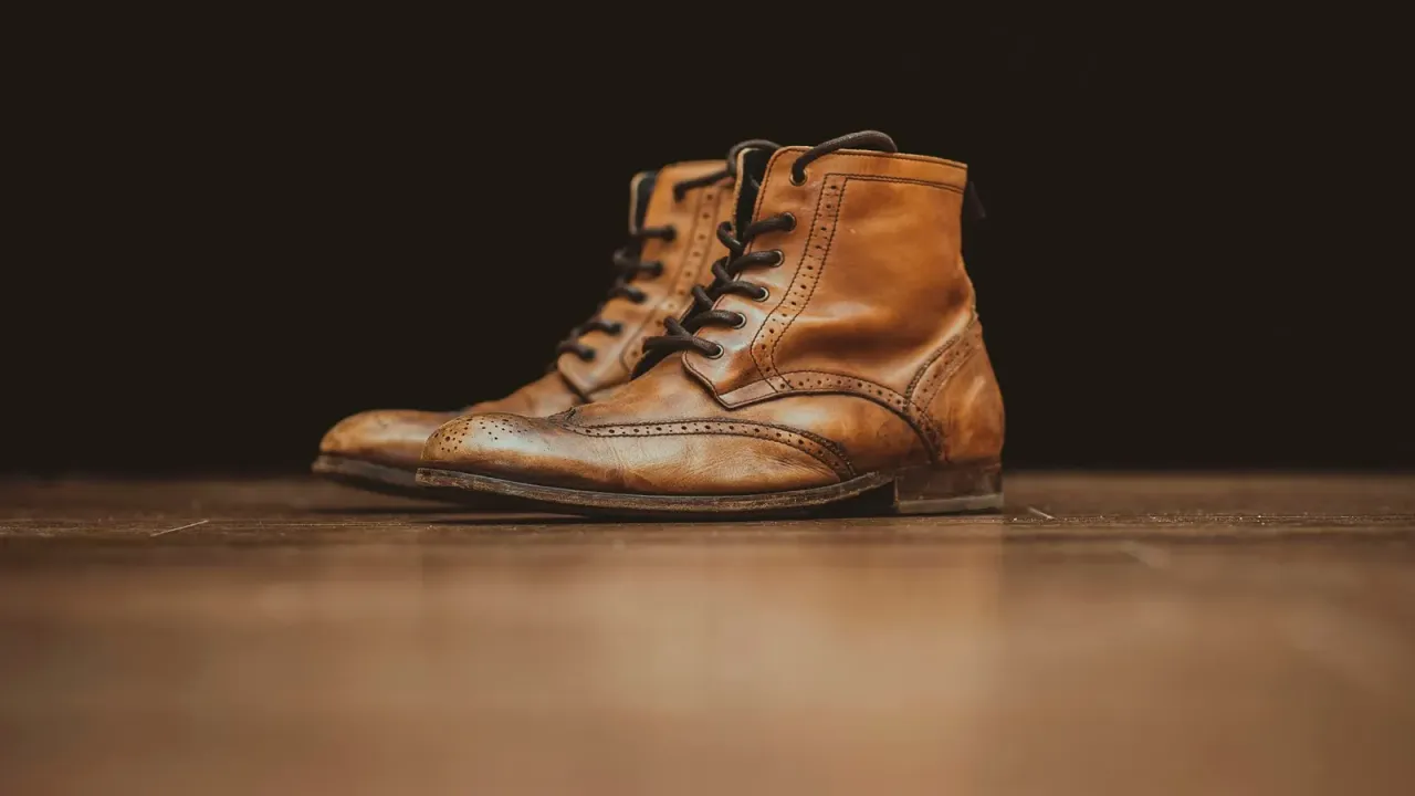Par de botas de couro marrom sobre bancada escura