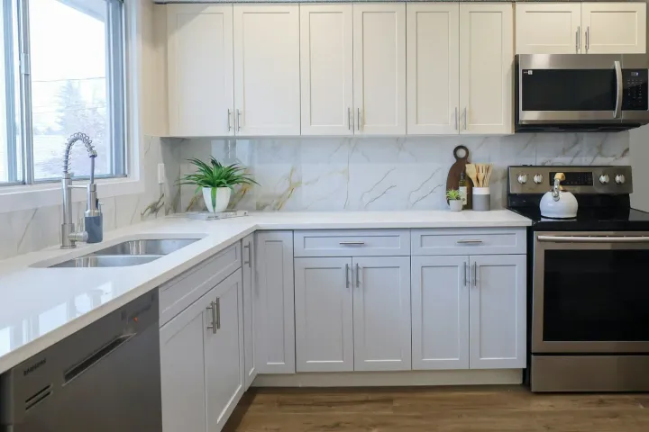 Cozinha clara com forno, micro-ondas e armários limpos