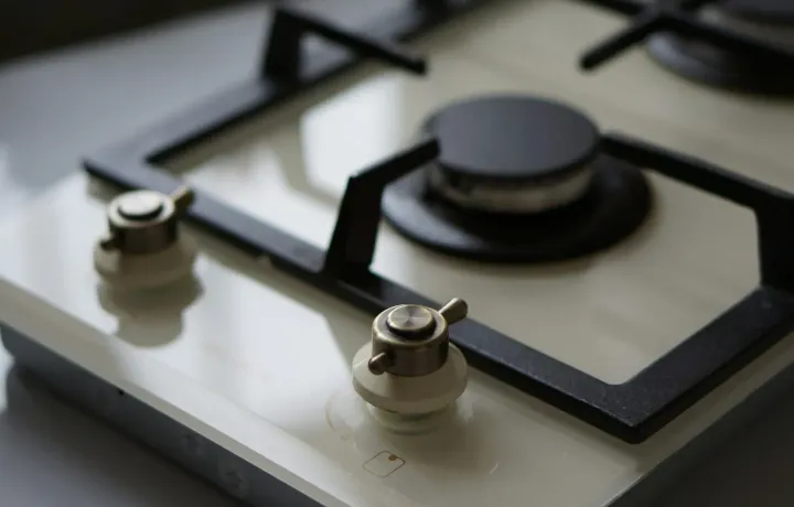 Close-up de cooktop de vidro com botões metálicos limpos