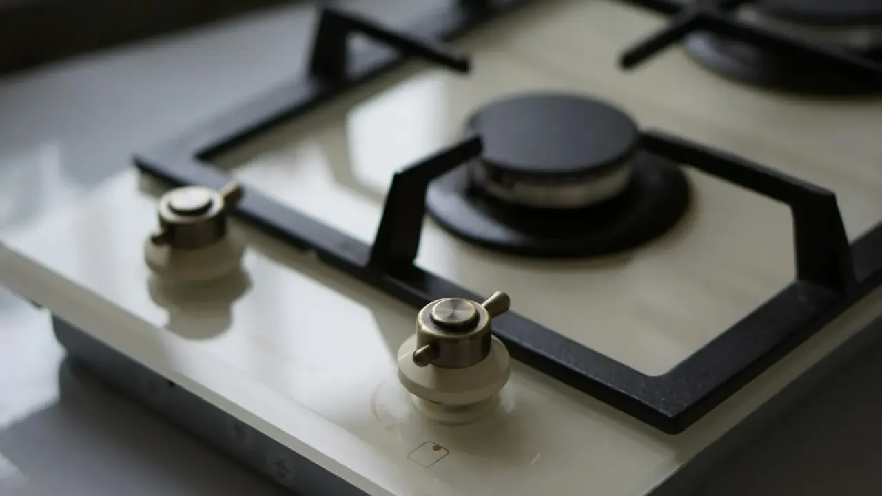 Close-up de cooktop de vidro com botões metálicos limpos