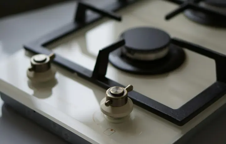 Close-up de cooktop de vidro com botões metálicos limpos