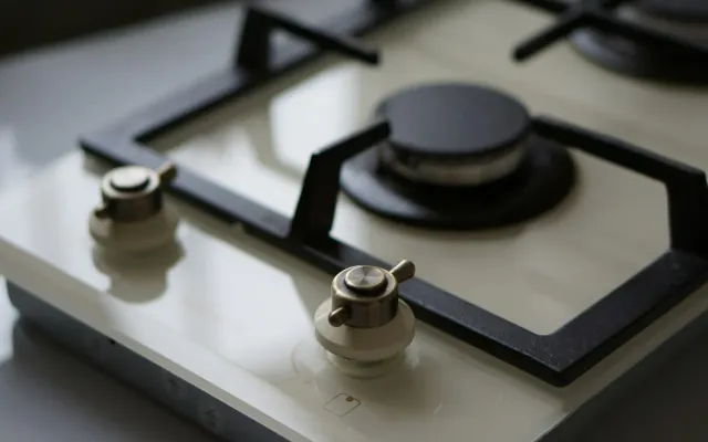 Close-up de cooktop de vidro com botões metálicos limpos