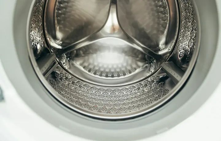 Tambor limpo e vazio de máquina de lavar visto de perto
