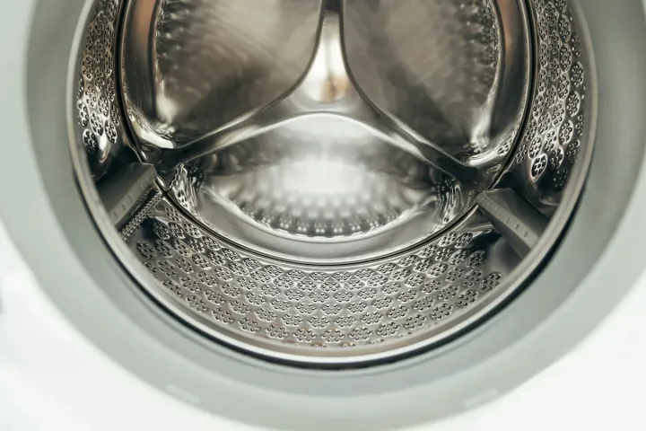 Tambor limpo e vazio de máquina de lavar visto de perto