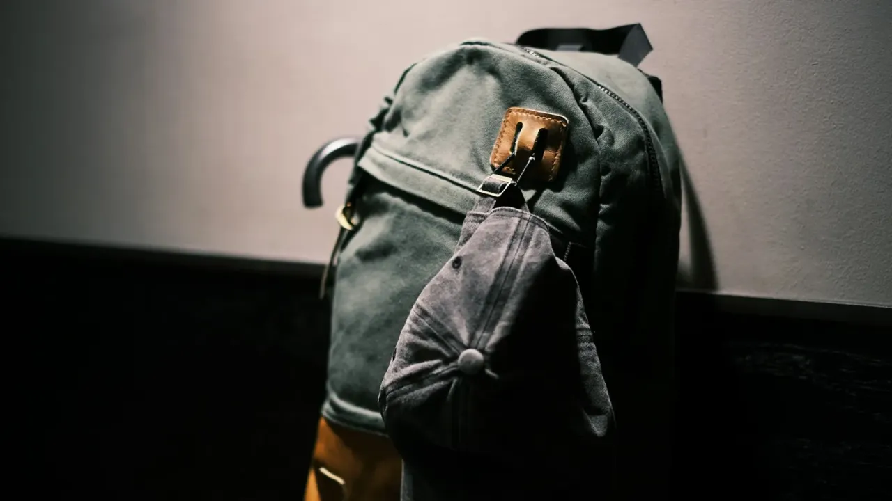Mochila preta apoiada sobre mesa de madeira