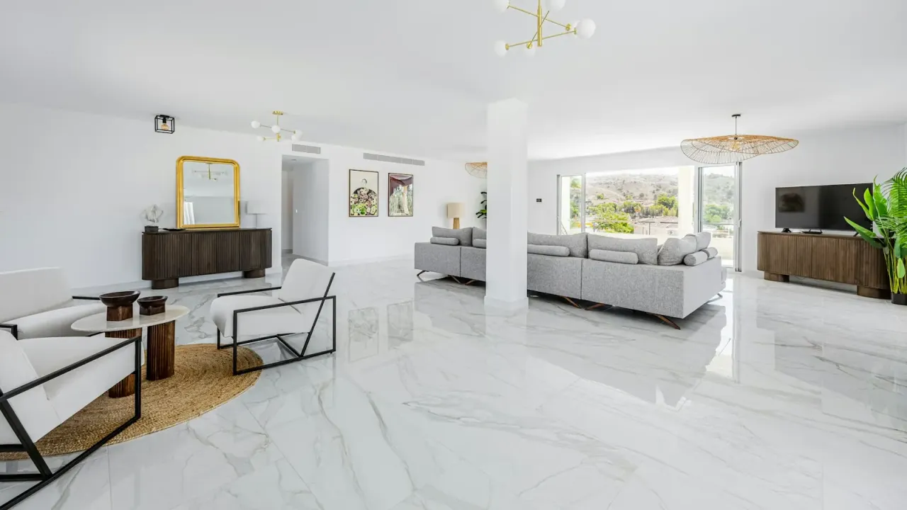 Sala ampla com piso claro polido refletindo a luz
