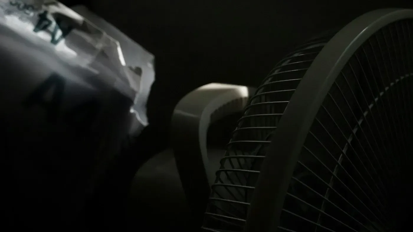 Close-up de grade e pás brancas de um ventilador elétrico