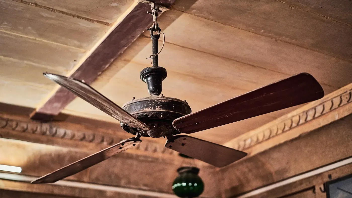 Ventilador de teto branco instalado em um forro claro